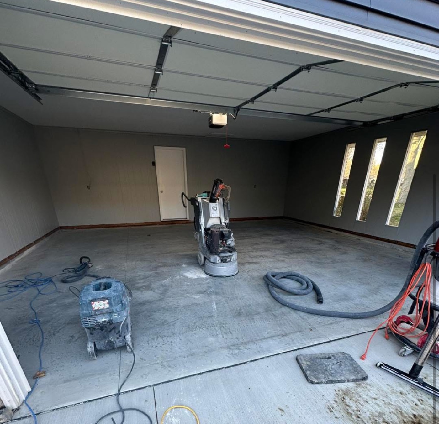 Before: garage concrete floor being ground and prepped