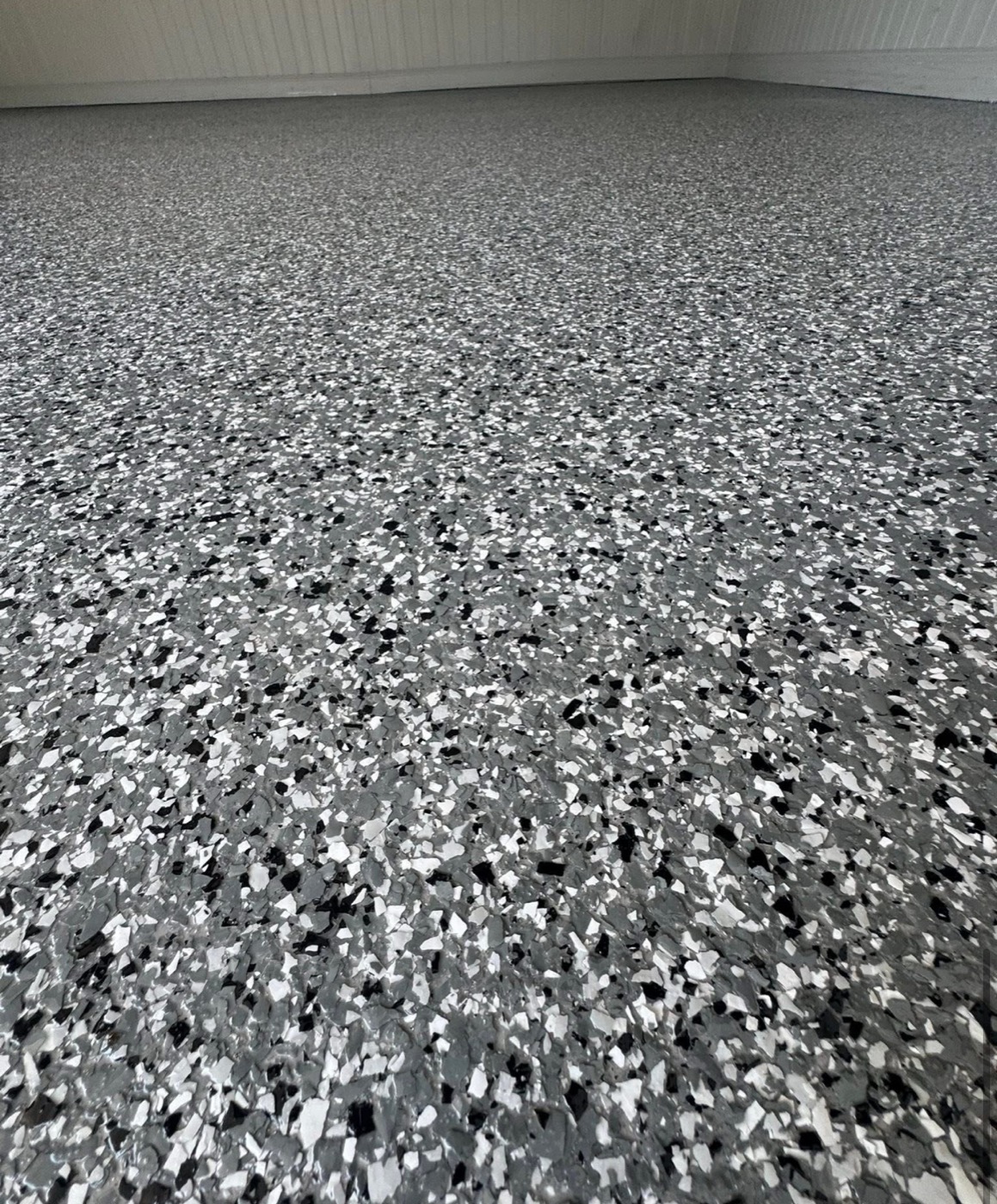 Close-up of black, white and grey full broadcast flake epoxy coating